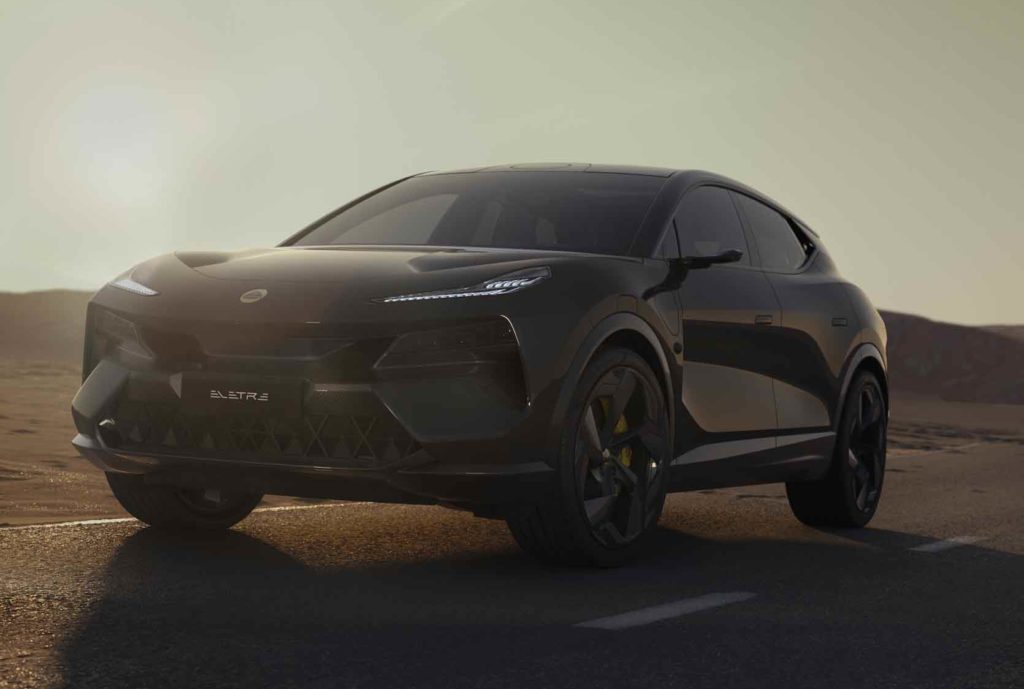Ein dunkler, fast schwarzer Lotus Eletre SUV steht im Profil bei Sonnenuntergang auf einer Straße. Die Scheinwerfer sind leicht beleuchtet und die Umgebung ist eine Wüstenlandschaft.
