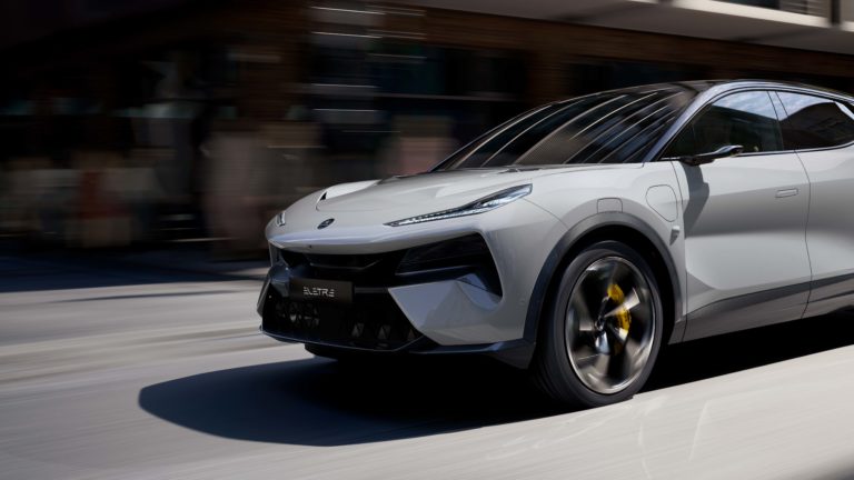 Weißer Lotus Eletre fährt dynamisch durch die Stadt, mit verschwommenem Hintergrund.