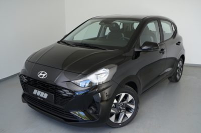 Ein schwarzer Hyundai i10 Trend Limousine Kleinwagen steht in einem Fotostudio auf hellem Boden.